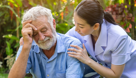A female nurse assists an elderly patient.